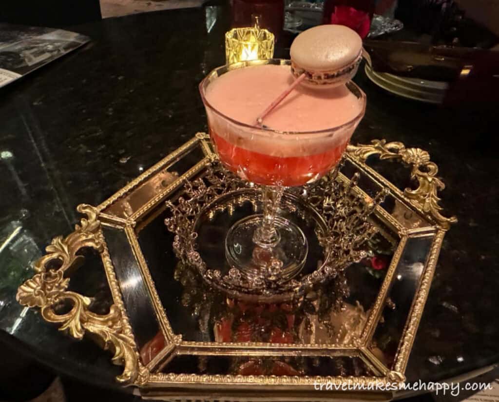 cocktail with a crown and macaroon vanderpump paris las vegas bar