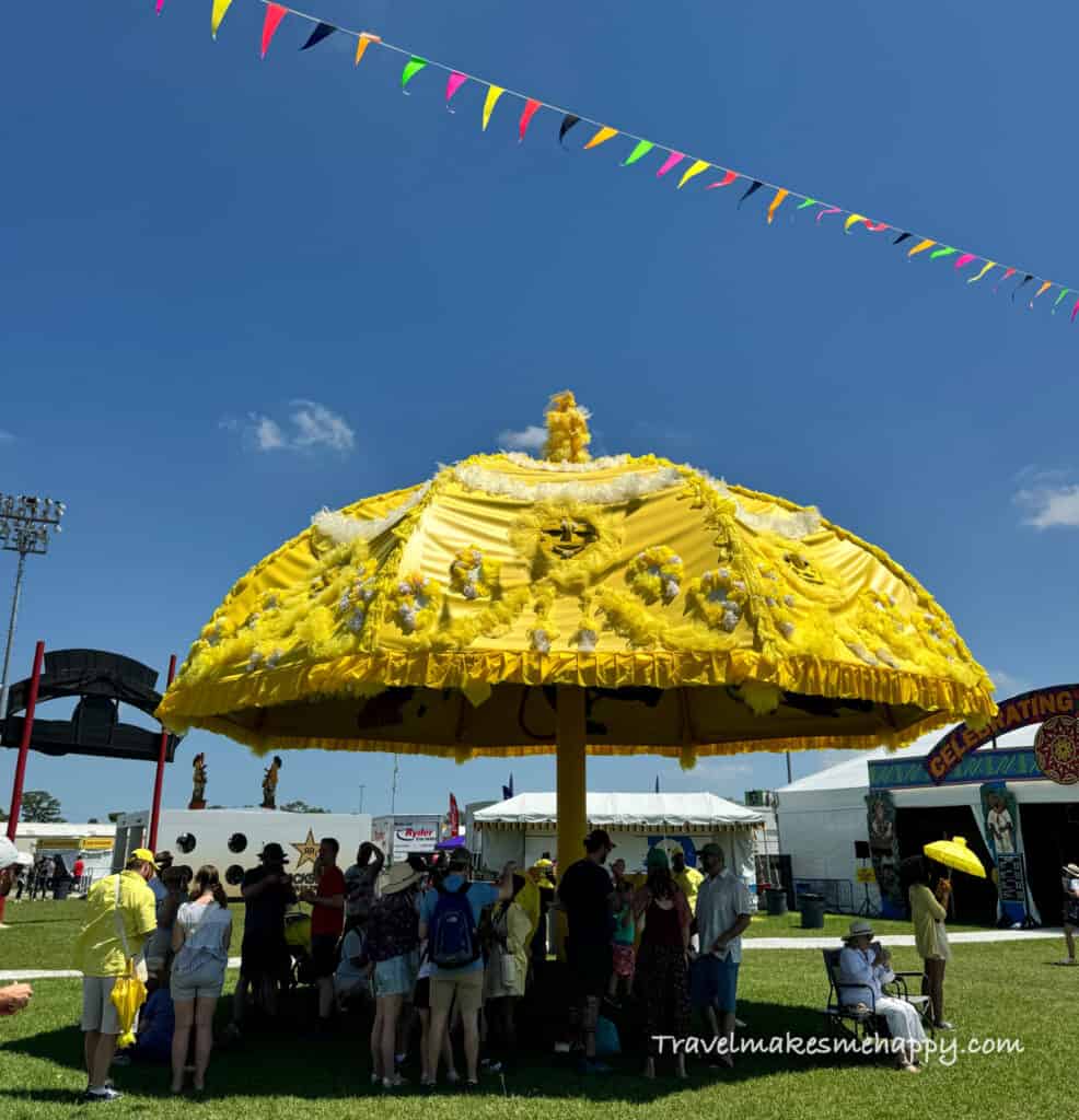 There's lots of people watching fun at new orleans jazz fest yellow umbrella 