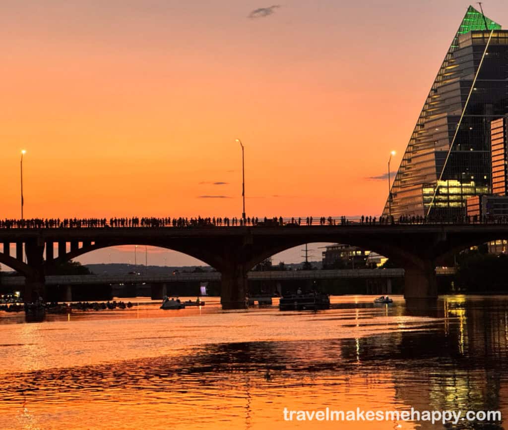 Austin congress street bridge at sunset with silhouette of crowd of people waiting for the famous bats to emerge from under the bridge
