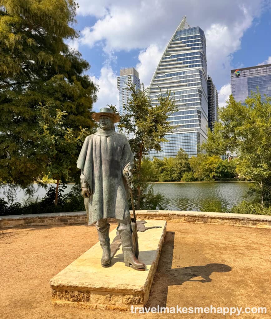 Modern cityscape with an iconic Stevie Ray Vaughan statue by Lady Bird lake with the Austin skyline in showcasing contemporary architecture in the city of Austin, Texas.